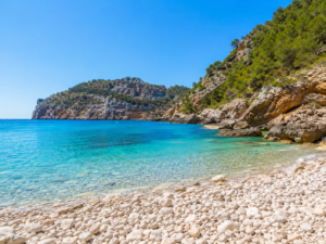 Пляж Cala Granadella в Jávea на Коста-Бланке с бирюзовой водой, скалами и красивой бухтой для SUP-прогулок